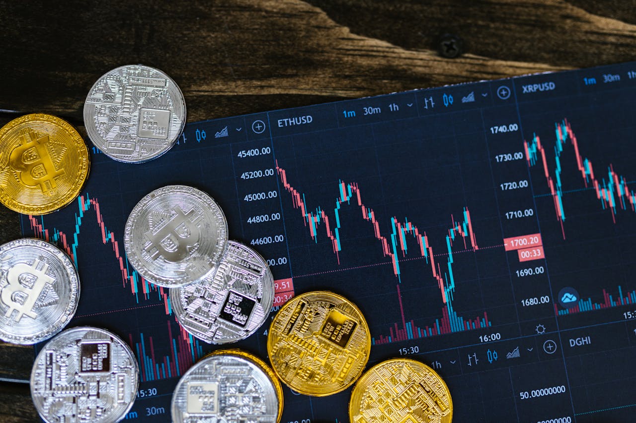 gallery-1 Close-up of gold and silver cryptocurrency coins on a digital trading chart.